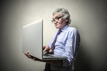 elderly man holding a laptop